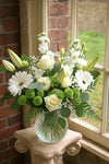 Sympathy flowers in white and green tones for delivery in Maple Ridge. Garden-style bouquet with roses, lisianthus, lilies and chrysanthemums in a clear glass vase.